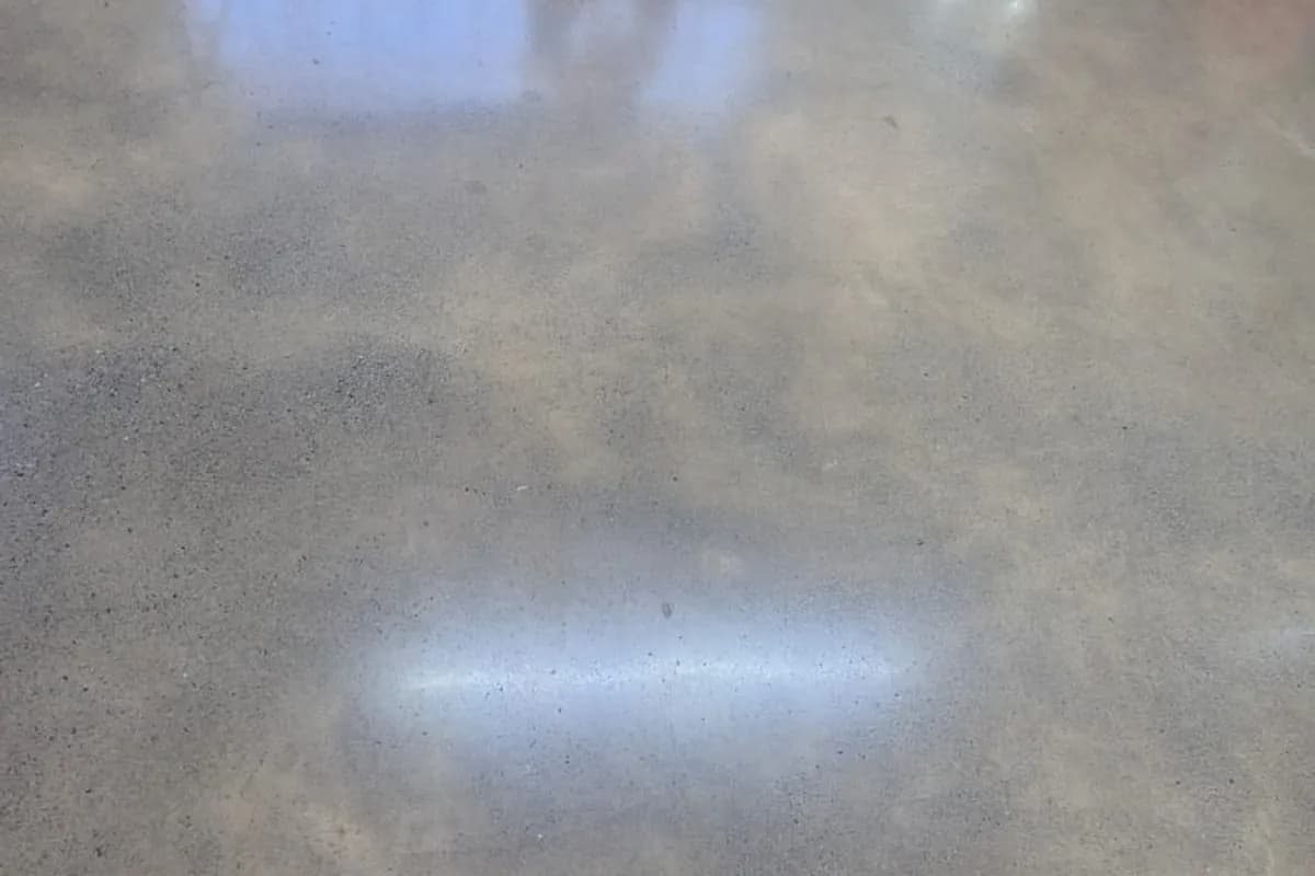 Piso de concreto polido refletindo a iluminação em área de circulação